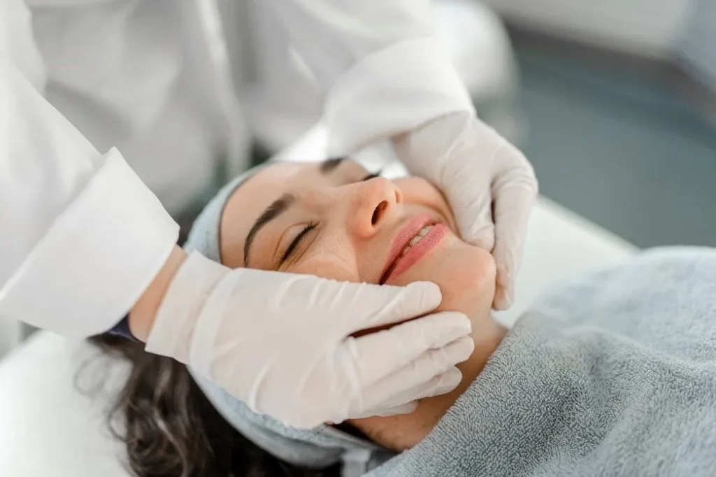 A woman getting her teeth checked by an esthetician.
